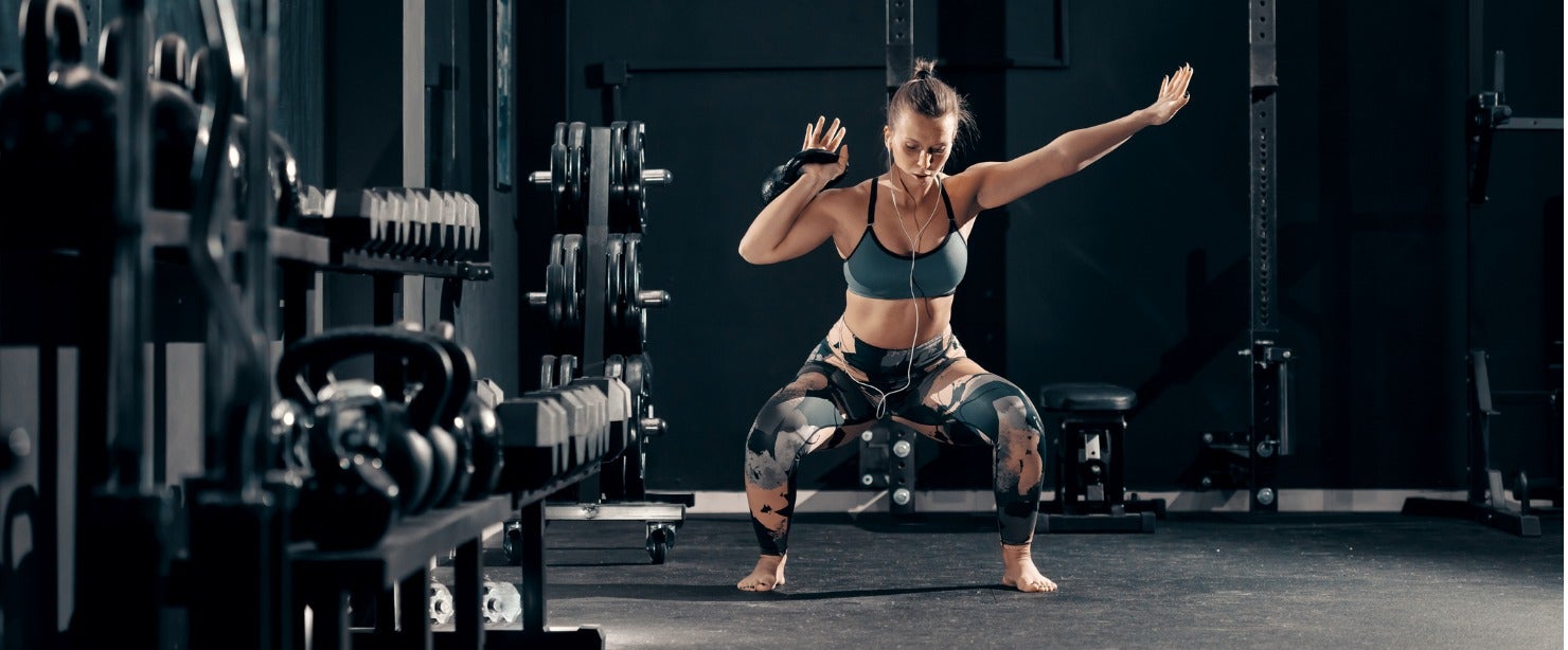 strong woman doing kettlebell squat to press