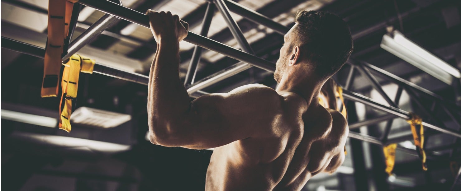 athletic man doing pullup on bar