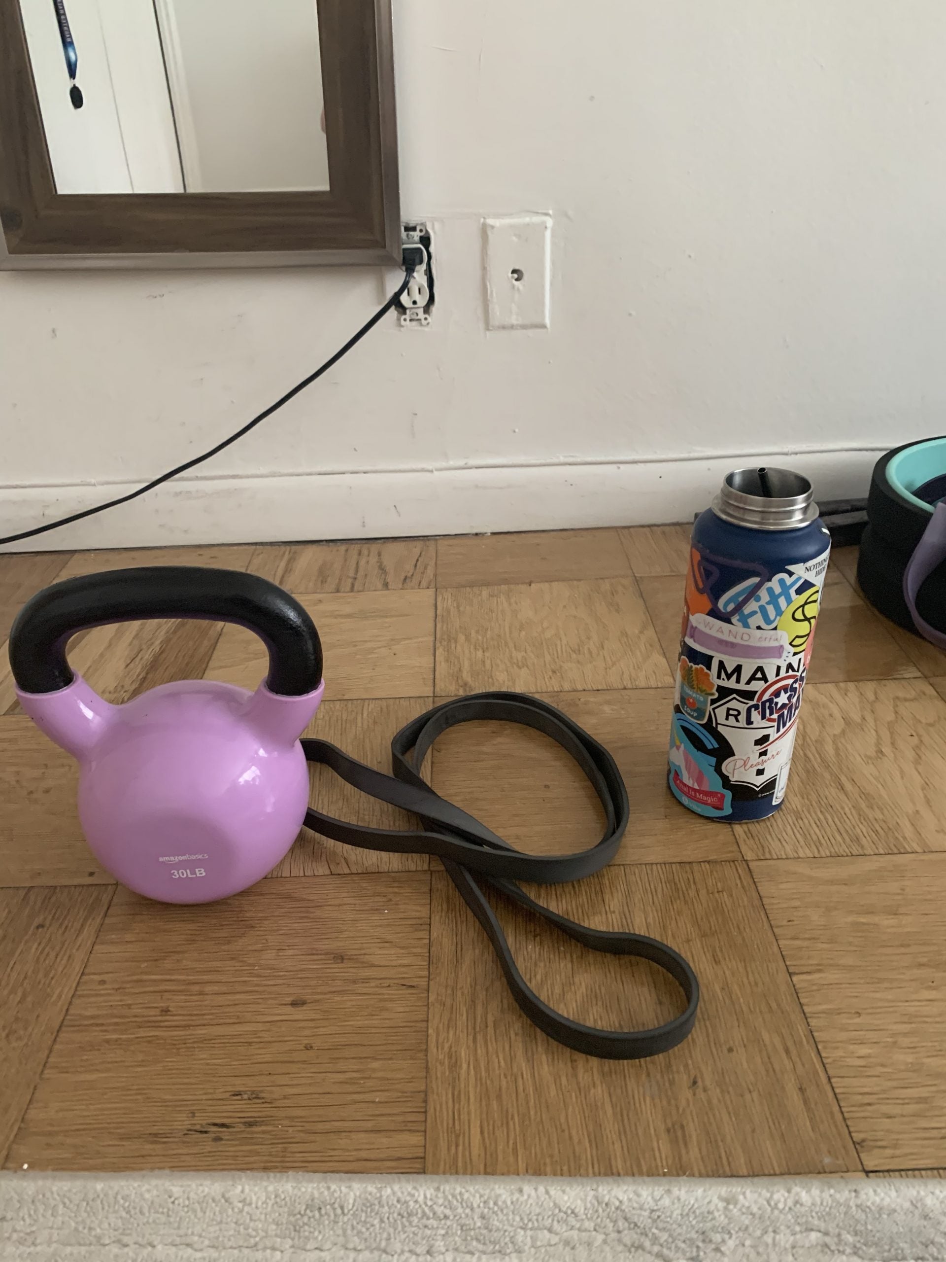 kettlebell with resistance band and water bottle on apartment floor