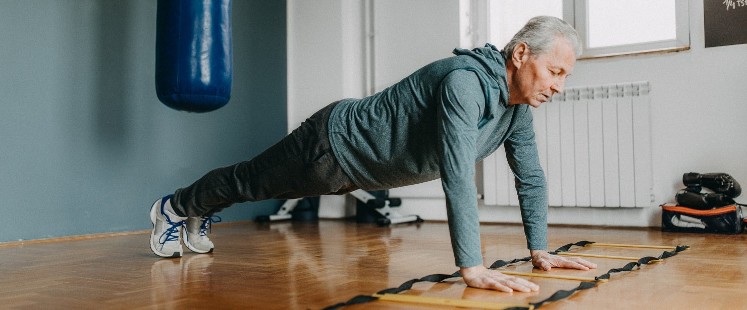 older man doing plank at home