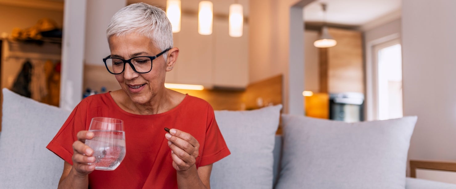 older woman taking supplement