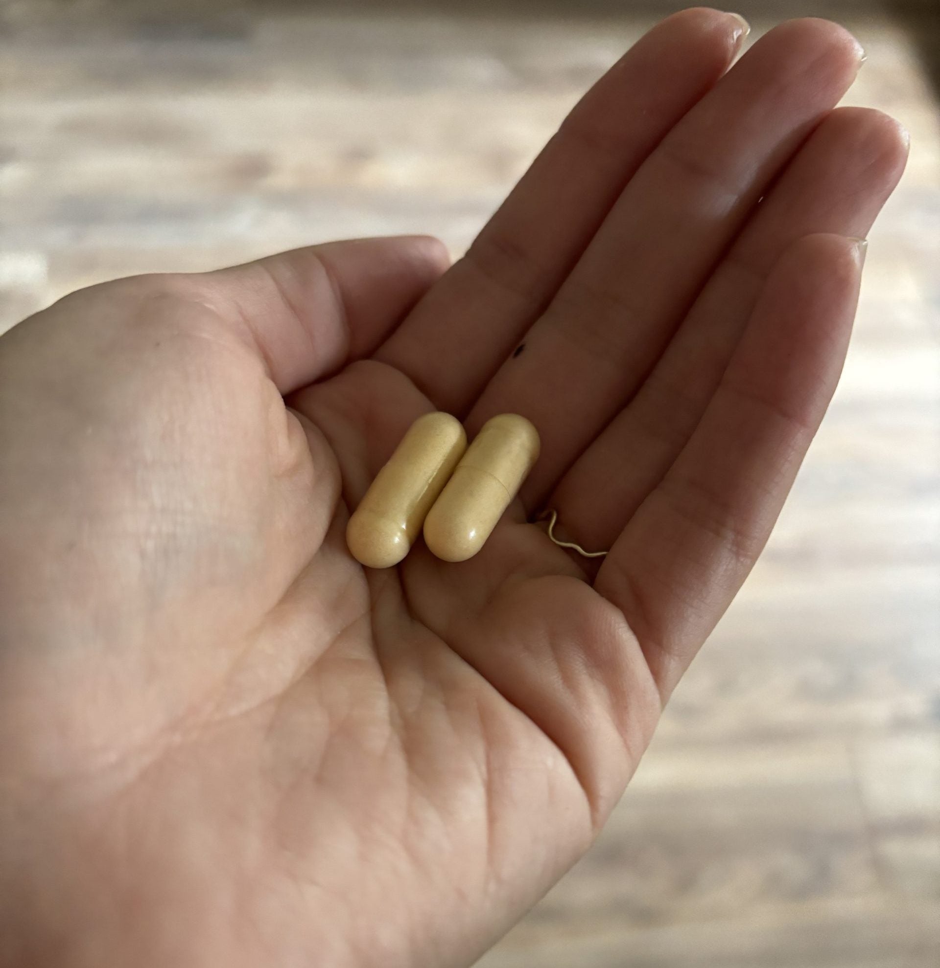 hand holding capsules of Zhou Nutrition Hairfluence supplement