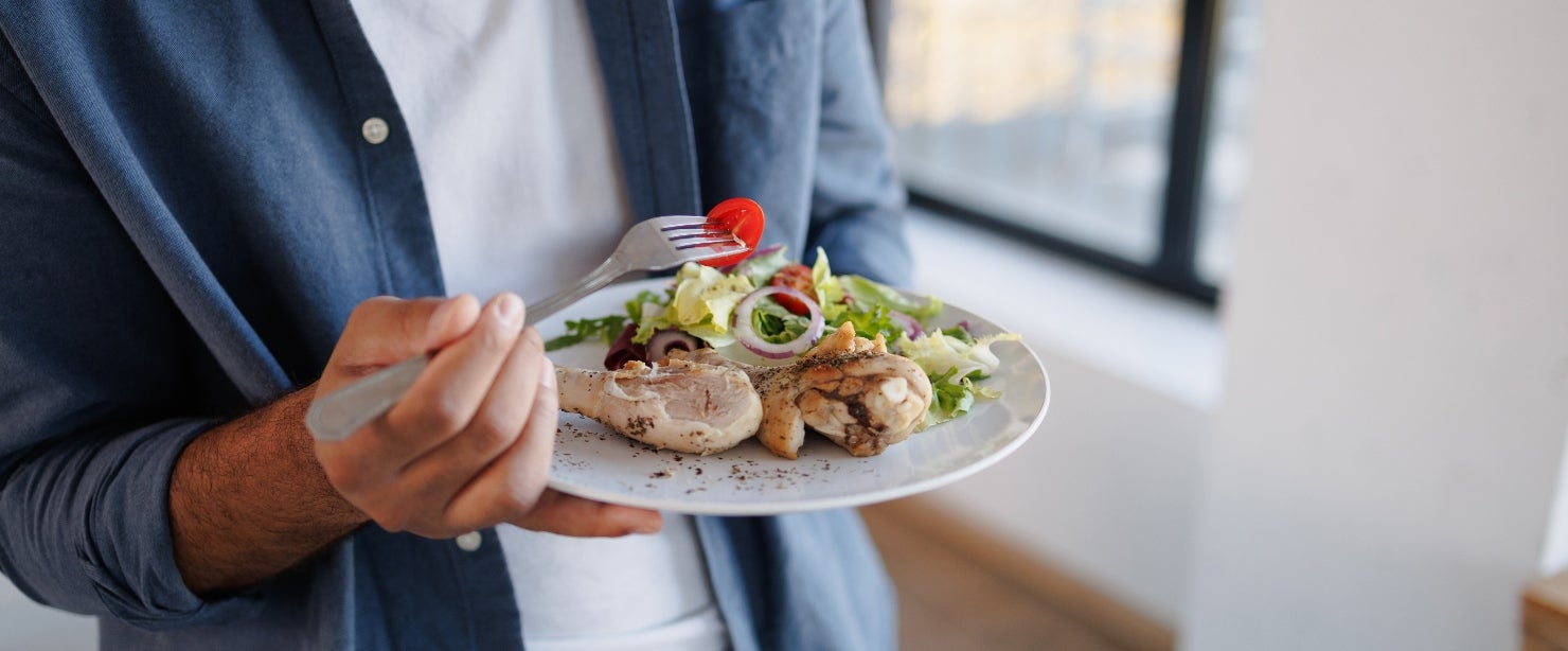 more protein: man eating chicken and salad