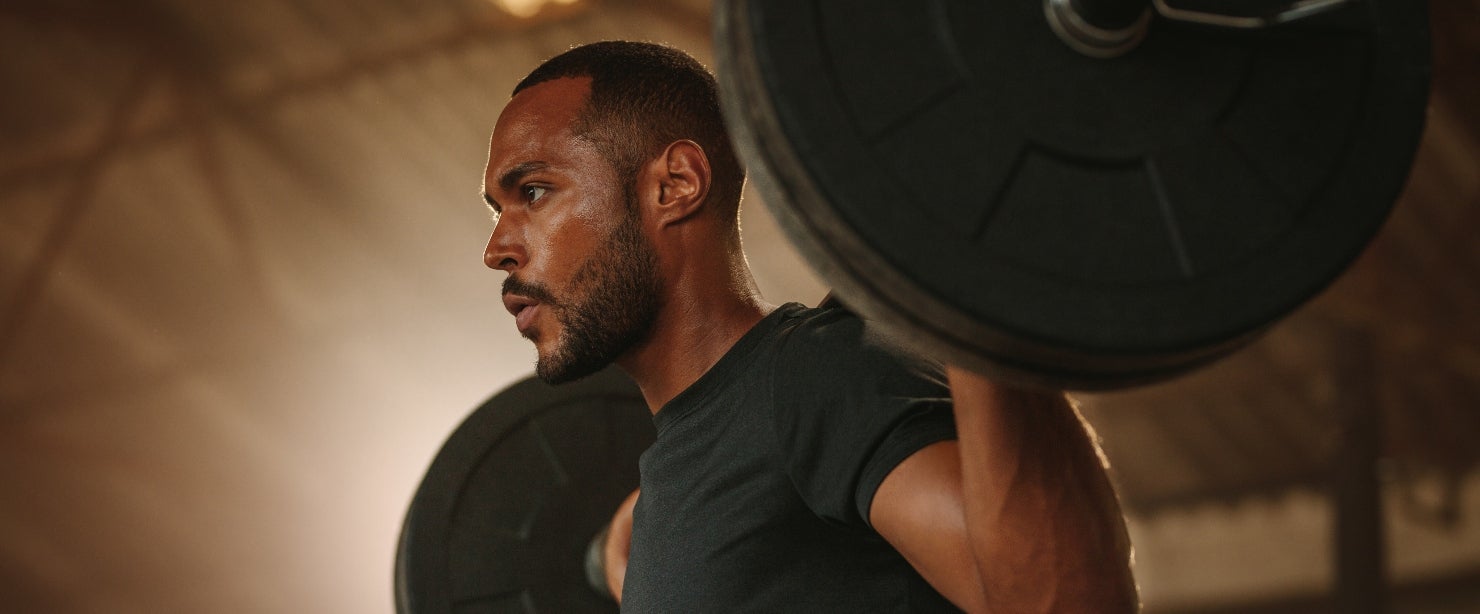 excess estrogen men: man lifting barbell