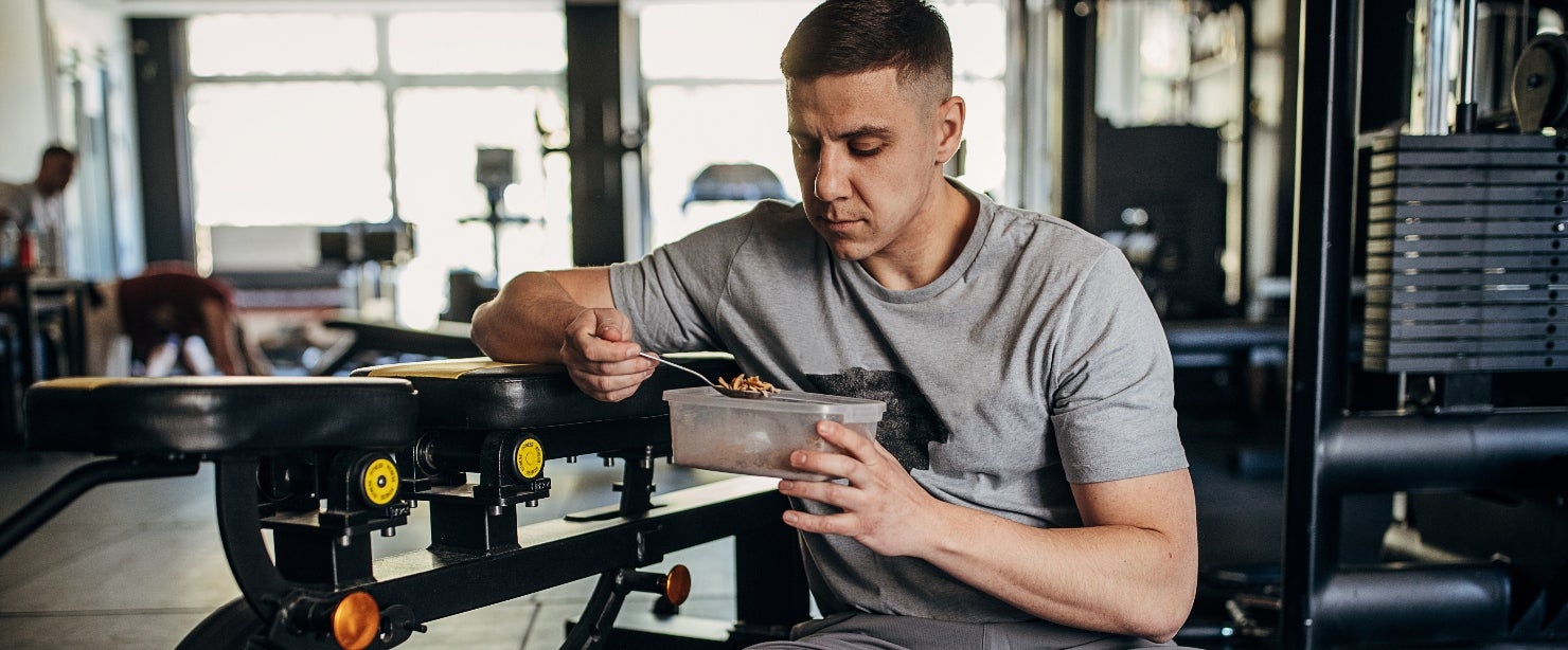 protein cycling: man eating in the weight room
